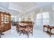Formal dining room with marble floors, a decorative chandelier, and a large window with elegant drapes at 124 Barrington Dr, Brandon, FL 33511