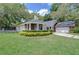 Beautiful home boasts lush green lawn, mature landscaping, and a brick-accented facade at 124 Barrington Dr, Brandon, FL 33511