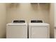 Efficient laundry room setup with a side by side washer and dryer under a wire shelf at 15038 Zircon Red Dr, Wimauma, FL 33598