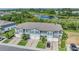 Aerial view of townhomes with a pond in the background and well manicured lawns at 1594 Cassius St, Lutz, FL 33549