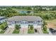 Aerial view of townhomes with a pond in the background and well manicured lawns at 1594 Cassius St, Lutz, FL 33549