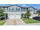 Charming townhome featuring a gray exterior, white garage doors, and well-maintained landscaping at 1594 Cassius St, Lutz, FL 33549