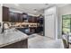 Kitchen with dark cabinets, stainless steel appliances, granite countertops, and tile floors at 1594 Cassius St, Lutz, FL 33549