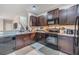 Well-lit kitchen featuring granite counters, dark wood cabinets, and modern appliances at 1594 Cassius St, Lutz, FL 33549