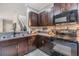 Modern kitchen with granite countertops, stainless appliances and stylish dark wood cabinetry at 1594 Cassius St, Lutz, FL 33549