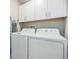 Bright laundry room with white cabinets and modern washer and dryer units at 1594 Cassius St, Lutz, FL 33549