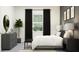 Stylish bedroom showcasing a modern design with a gray dresser, potted plant, and refined black curtains at 16983 Falling Waters Ct, Land O Lakes, FL 34638