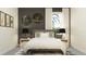 Modern bedroom with a gray upholstered headboard, stylish artwork, and plenty of natural light from the window at 16983 Falling Waters Ct, Land O Lakes, FL 34638