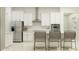 Bright kitchen boasts stainless steel appliances, white cabinets, and bar seating at 16983 Falling Waters Ct, Land O Lakes, FL 34638