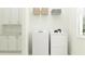 Well-lit laundry room with white washer, dryer, and built-in storage cabinets at 16983 Falling Waters Ct, Land O Lakes, FL 34638