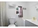 Bathroom with a toilet, gray vanity, and window with decorative curtain at 1722 48Th N Ave, St Petersburg, FL 33714