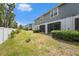 Side view of a backyard featuring a screened patio, shrubbery, and a white fence at 2140 Laceflower Dr, Brandon, FL 33510