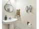 Stylish half bathroom featuring a pedestal sink, modern fixtures, and decorative wall art at 2140 Laceflower Dr, Brandon, FL 33510