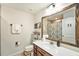Well-lit bathroom featuring a single sink vanity and decorative mirror with a shower, exuding a clean and refreshing ambiance at 2140 Laceflower Dr, Brandon, FL 33510