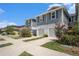 Exterior view of townhomes featuring a gray exterior, well-kept lawns, and concrete driveways at 2140 Laceflower Dr, Brandon, FL 33510