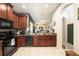Well-equipped kitchen featuring wooden cabinets, black appliances, and a view into the living area at 2140 Laceflower Dr, Brandon, FL 33510