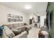 Inviting living room featuring a comfortable gray sectional sofa, tile floors, and modern décor at 2140 Laceflower Dr, Brandon, FL 33510
