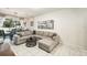 Cozy living room showcasing a gray sectional sofa, tile floors, and access to the dining area at 2140 Laceflower Dr, Brandon, FL 33510