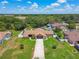 Expansive aerial view of a one-story home with a fenced yard and a long driveway in a lush, green neighborhood at 2436 Covington Ave, Spring Hill, FL 34608