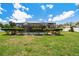 Scenic backyard view showcasing a screened pool surrounded by mature hedges and green grass at 2436 Covington Ave, Spring Hill, FL 34608