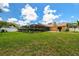 Beautiful backyard featuring a screened pool, lush lawn, and well-maintained landscaping at 2436 Covington Ave, Spring Hill, FL 34608