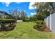 Expansive backyard showcasing lush lawn, mature trees, and partial view of a screened pool at 2436 Covington Ave, Spring Hill, FL 34608