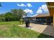 Lovely backyard featuring a pool area, a barbecue and chairs set on gravel, and a well-manicured lawn at 2436 Covington Ave, Spring Hill, FL 34608