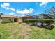 Spacious backyard featuring a screened pool, mature hedges, and a well-maintained lawn at 2436 Covington Ave, Spring Hill, FL 34608