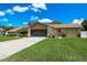 Beautiful one-story home featuring a long driveway, a two-car garage, stone accents, and a well-maintained lawn at 2436 Covington Ave, Spring Hill, FL 34608