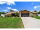 Charming one-story home features a two-car garage, stone accents, landscaped yard, and a well-manicured lawn at 2436 Covington Ave, Spring Hill, FL 34608