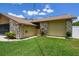 Side view of a home featuring a two-car garage, stone accents, and a well-maintained lawn at 2436 Covington Ave, Spring Hill, FL 34608