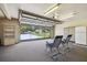 Garage with overhead door, carpeting, utility cabinets, and two rocking chairs at 2436 Covington Ave, Spring Hill, FL 34608