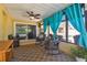 Enclosed lanai featuring bright turquoise drapes, rocking chairs, and a view of the pool at 2436 Covington Ave, Spring Hill, FL 34608