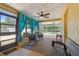 Enclosed lanai with turquoise drapes, rocking chairs, and a view of the backyard at 2436 Covington Ave, Spring Hill, FL 34608