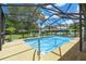 Beautiful screened-in pool offering a relaxing oasis with lush landscaping and privacy at 2436 Covington Ave, Spring Hill, FL 34608
