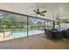 Screened-in pool area with a patio table set, ceiling fans, and well-maintained landscaping at 2436 Covington Ave, Spring Hill, FL 34608