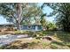 Backyard with a rustic fire pit area, complemented by mature shade trees and lush grass at 2616 47Th N Ave, St Petersburg, FL 33714
