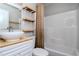 Updated bathroom with modern fixtures, wood shelves, and a shower-tub combo at 2616 47Th N Ave, St Petersburg, FL 33714