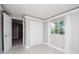 Bedroom boasts sliding closet, a window with white curtains, and gray floors at 2616 47Th N Ave, St Petersburg, FL 33714