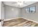 Well-lit bedroom features hardwood floors, a ceiling fan, and a view to the exterior at 2696 60Th Avenue W Ter # 10, Bradenton, FL 34207