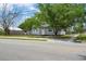 Exterior shot of single-story home with grey siding and mature shade tree at 2700 10Th W St, Palmetto, FL 34221
