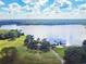 Breathtaking aerial view of the lake featuring a wooden pier, dock, and lush green shoreline against a cloudy blue sky at 2712 Clubhouse Dr, Plant City, FL 33566