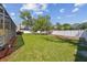 Large, beautifully maintained backyard featuring lush grass, mature shade trees, and a fenced perimeter at 2712 Clubhouse Dr, Plant City, FL 33566