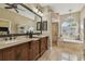 Elegant bathroom featuring dual vanities, a soaking tub, and a separate glass-enclosed shower at 2712 Clubhouse Dr, Plant City, FL 33566