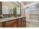 Bathroom showcasing a double vanity with granite countertop, and a tub-shower combo at 2712 Clubhouse Dr, Plant City, FL 33566