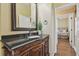Bathroom featuring a dark wood vanity with granite countertops and an elegant mirror at 2712 Clubhouse Dr, Plant City, FL 33566