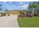 Charming yellow single-story home with a well-manicured lawn and three-car garage at 2712 Clubhouse Dr, Plant City, FL 33566