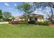Charming home with a well-manicured lawn, colorful landscaping, and a two-car garage at 2712 Clubhouse Dr, Plant City, FL 33566