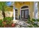 Elegant front entrance featuring double doors, stone flooring, and manicured shrubbery at 2712 Clubhouse Dr, Plant City, FL 33566