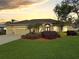 Beautifully landscaped yard with a well-maintained lawn and a charming one-story home at sunset at 2712 Clubhouse Dr, Plant City, FL 33566